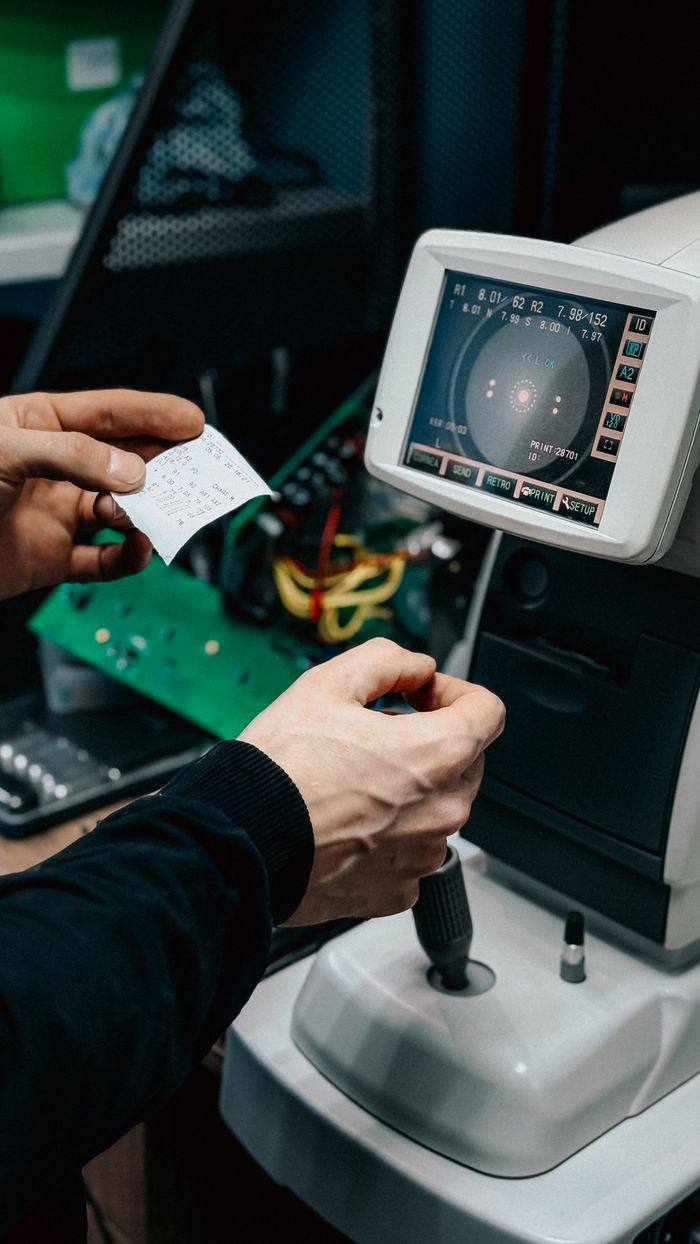The Art of Drawing Readers In: Your attractive post title goes here A technician operating an optical device in a laboratory, adjusting controls and viewing data output.